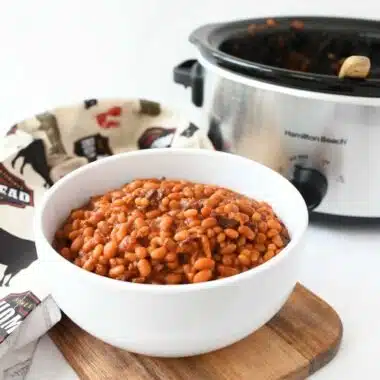 Slow cooker baked beans in a white bowl.