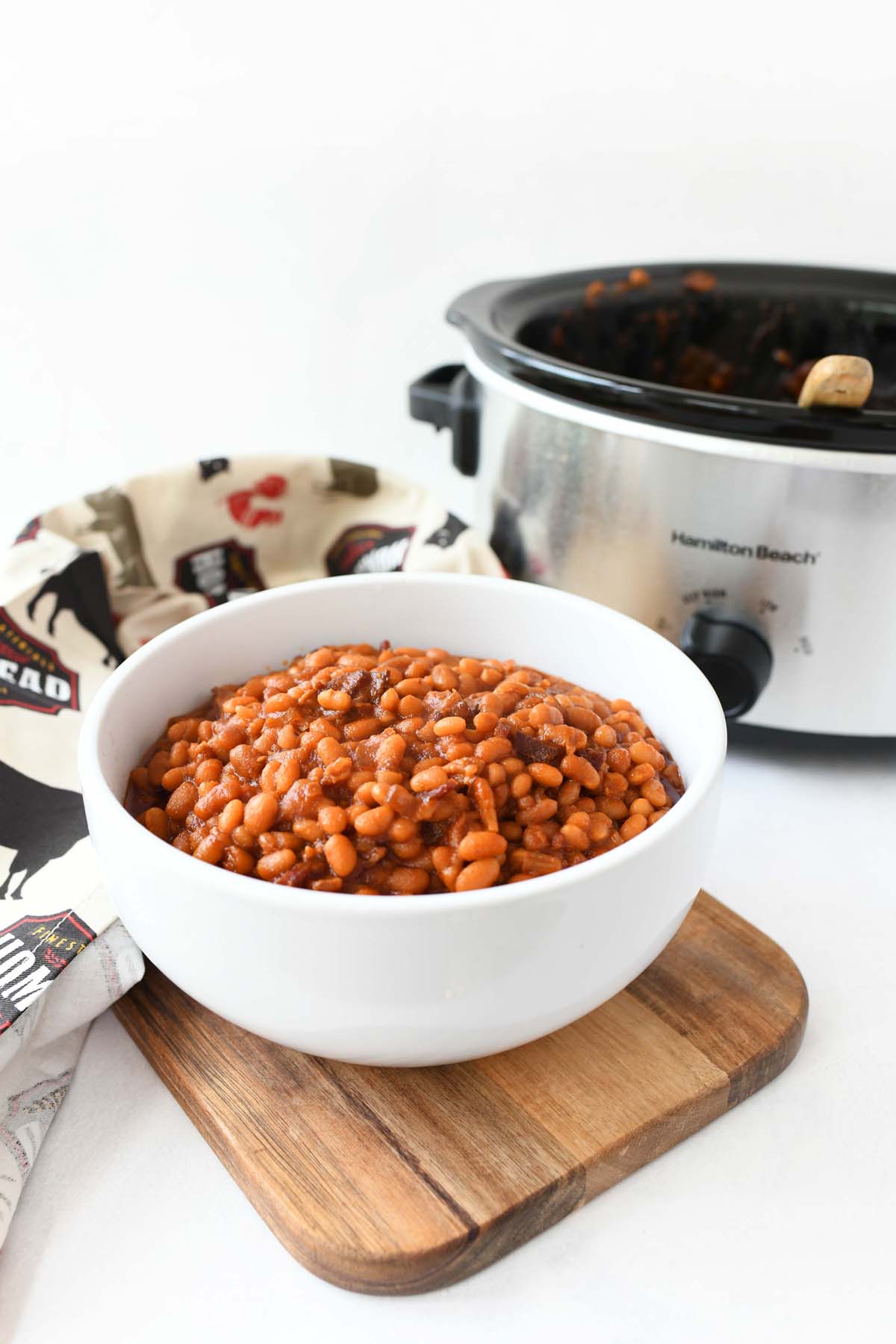 Slow cooker baked beans in a white bowl.