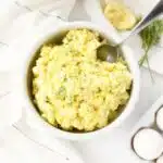 Egg salad in a white bowl with a spoon.