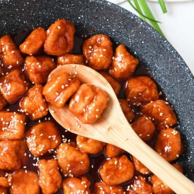 Sweet and Sour Popcorn Chicken on a wooden spoon.