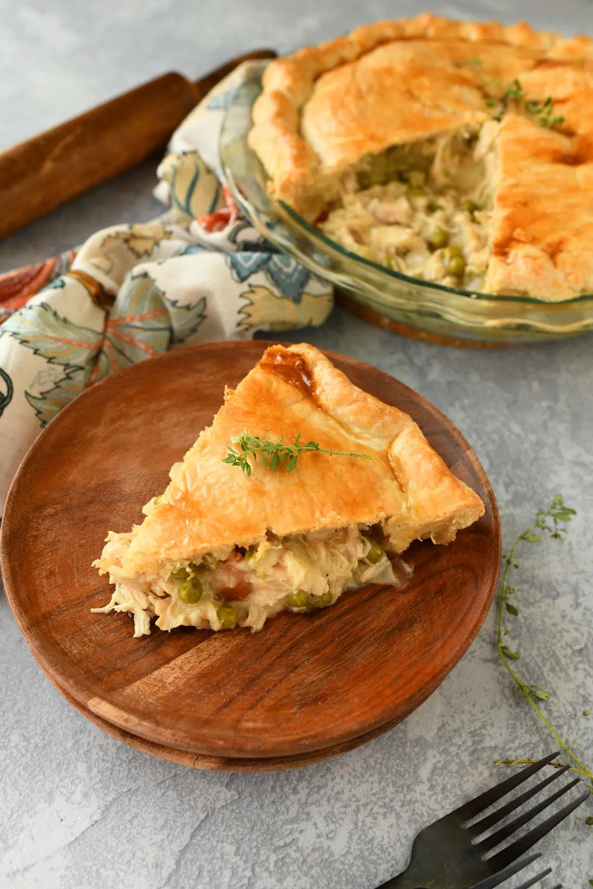 Up close shot of a slice of chicken pot pie on a wooden plate.