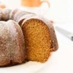 A slice of moist pumpkin bundt cake on a white plate.