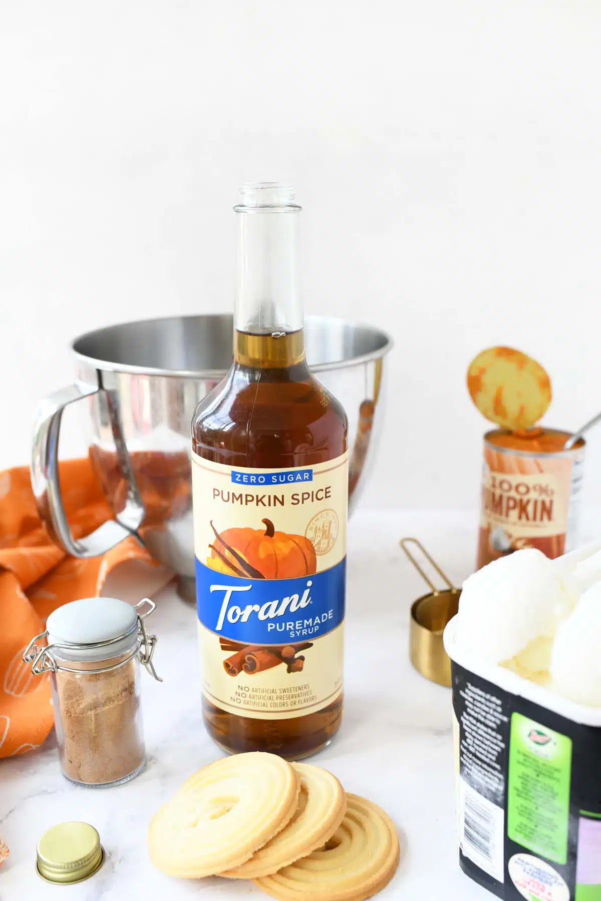 Ingredients for a sugar free pumpkin ice cream treat on a white table.