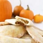 Pumpkin Mini Pies split in half with pumpkins in the background.