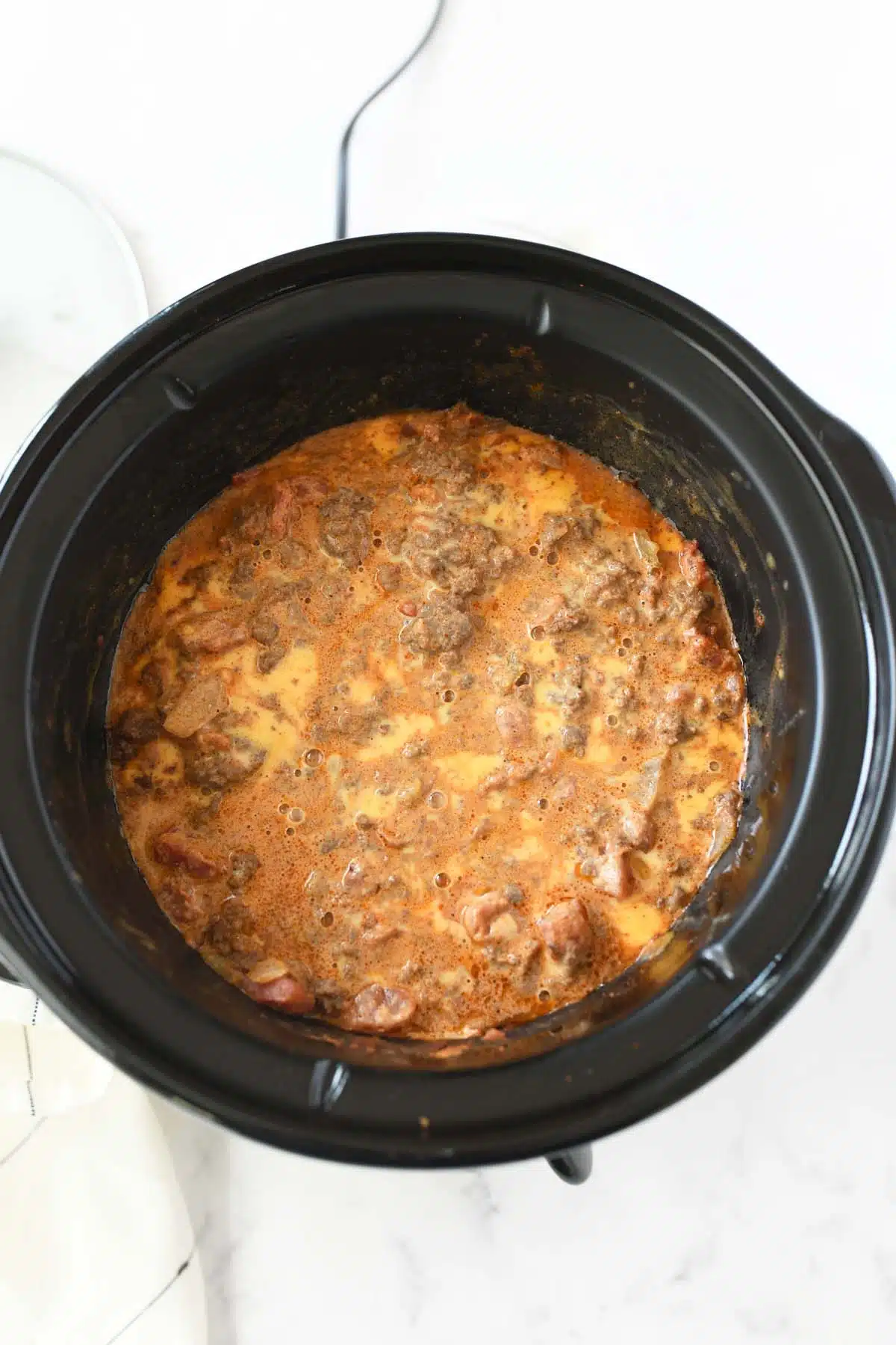 Slow cooked taco dip in a black slow cooker.