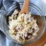 Tuna cranberry Salad on a wooden server with a blue napkin and wooden spoon.