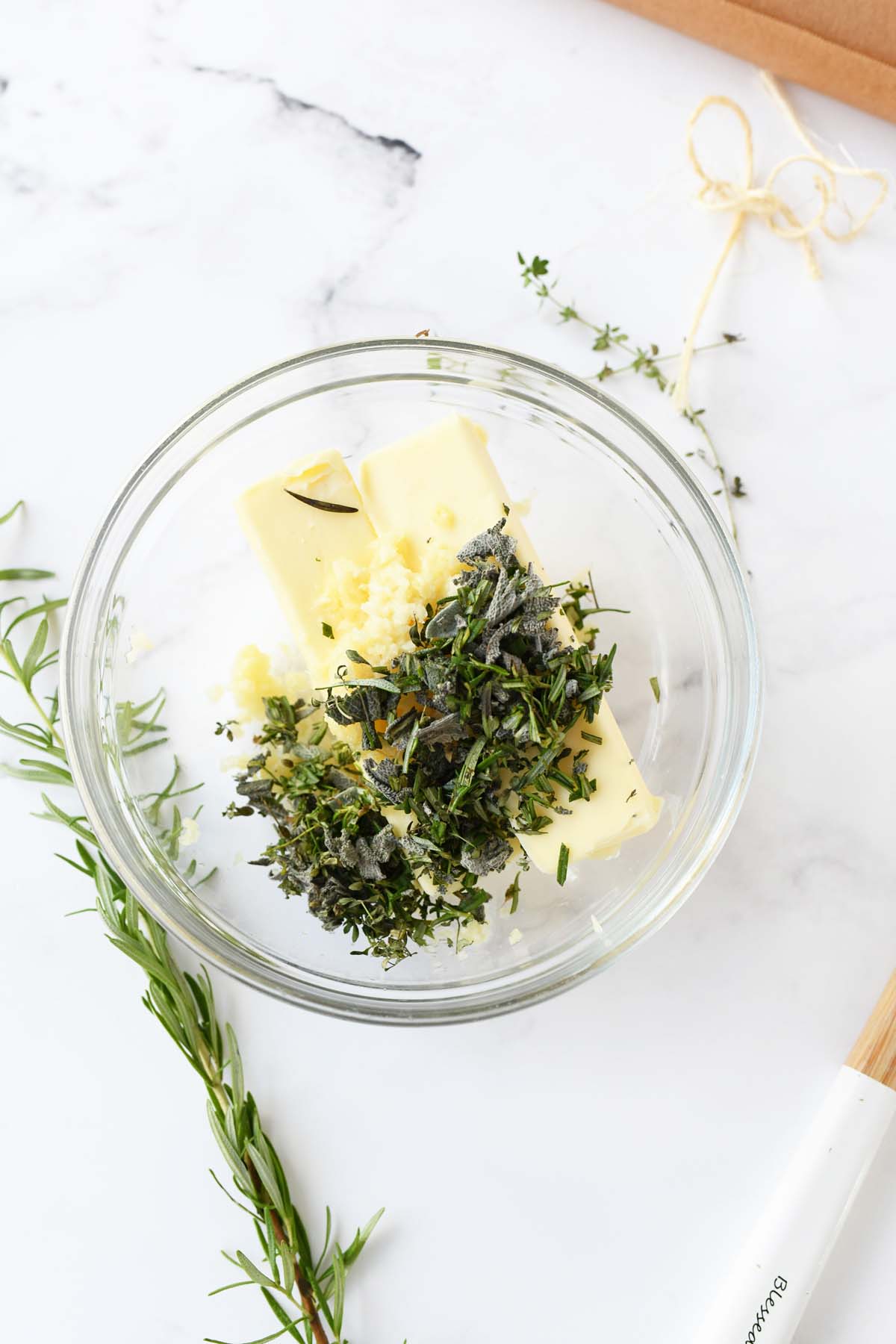 Chopped Herbs with Butter in a glass dish.