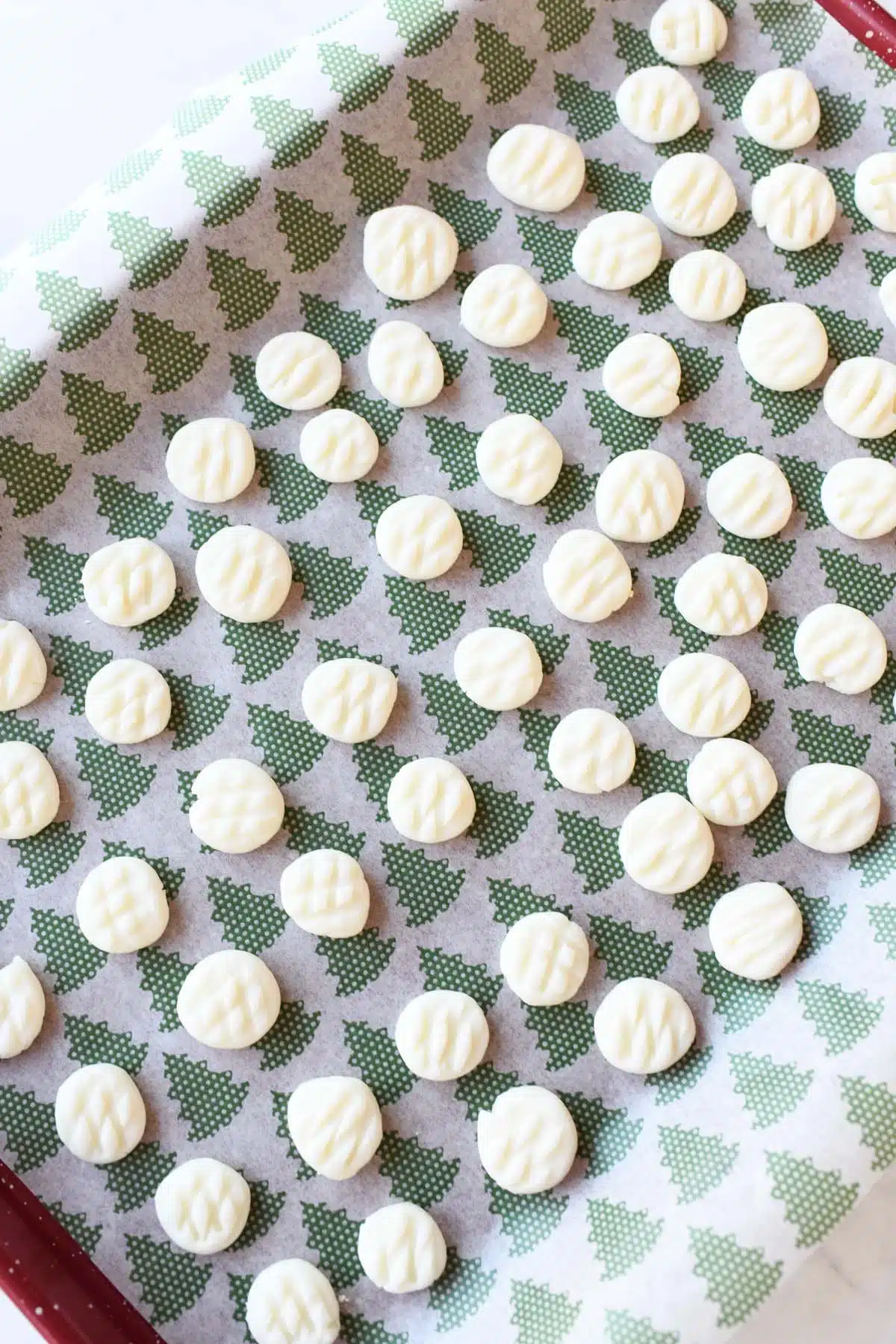 White cream cheese mints on tree parchment paper.