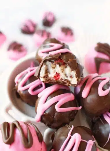 Milk chocolate coconut truffles with a pink swirl on top.