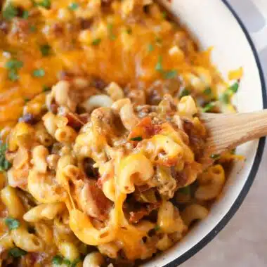 Cheesy chili mac on a wooden spoon.