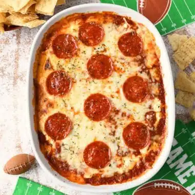 Pepperoni Pizza Dip with corn chips and green football napkins.