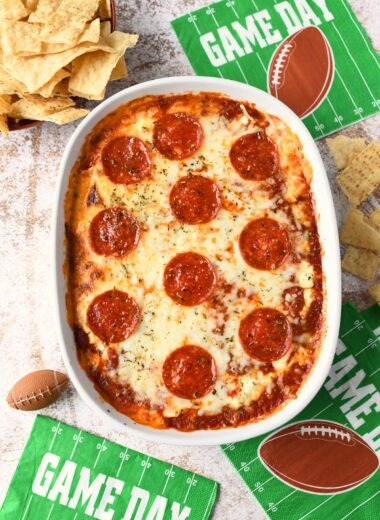 Pepperoni Pizza Dip with corn chips and green football napkins.