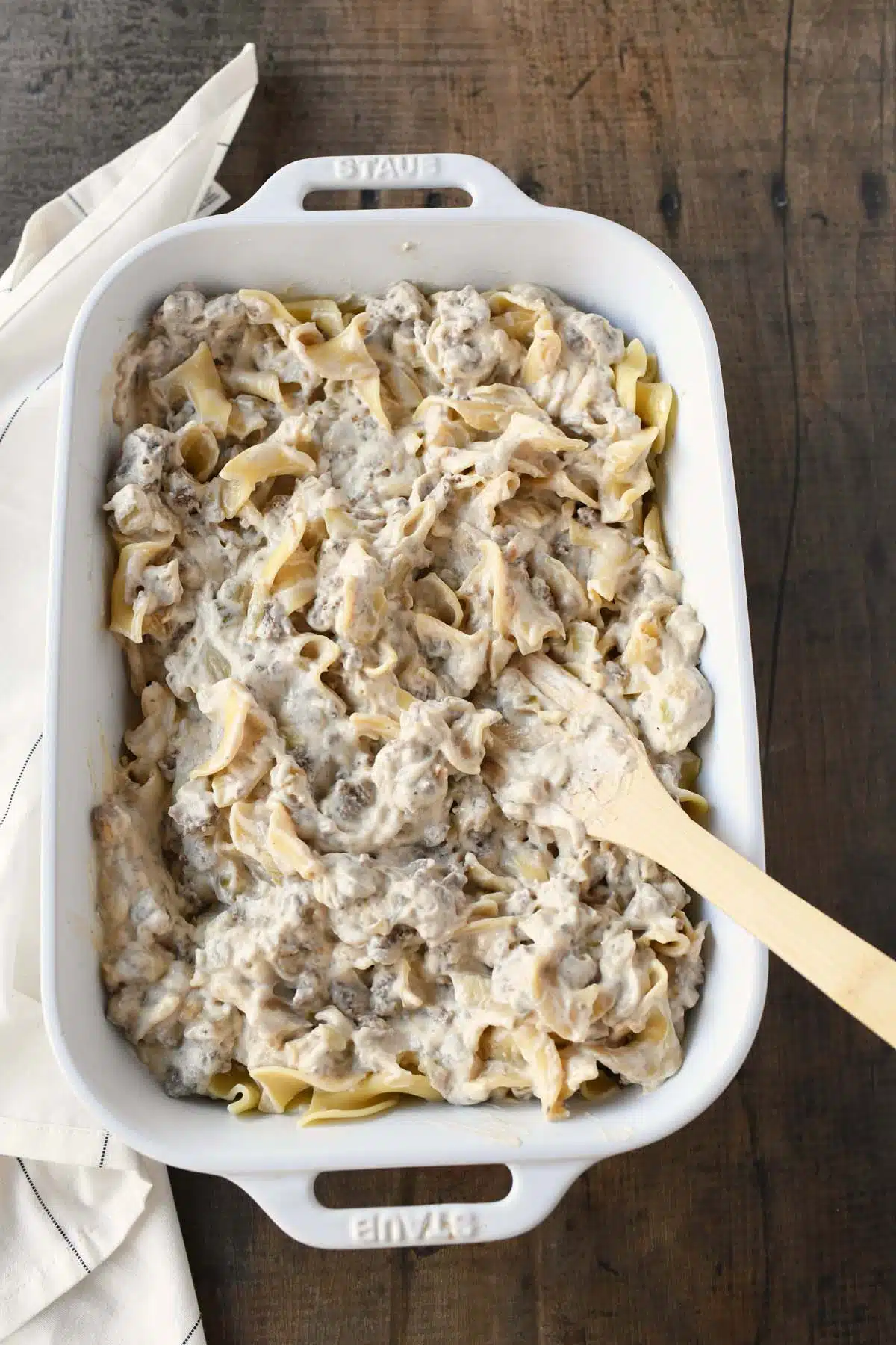 Creamy noodles and beef in a white baking dish.