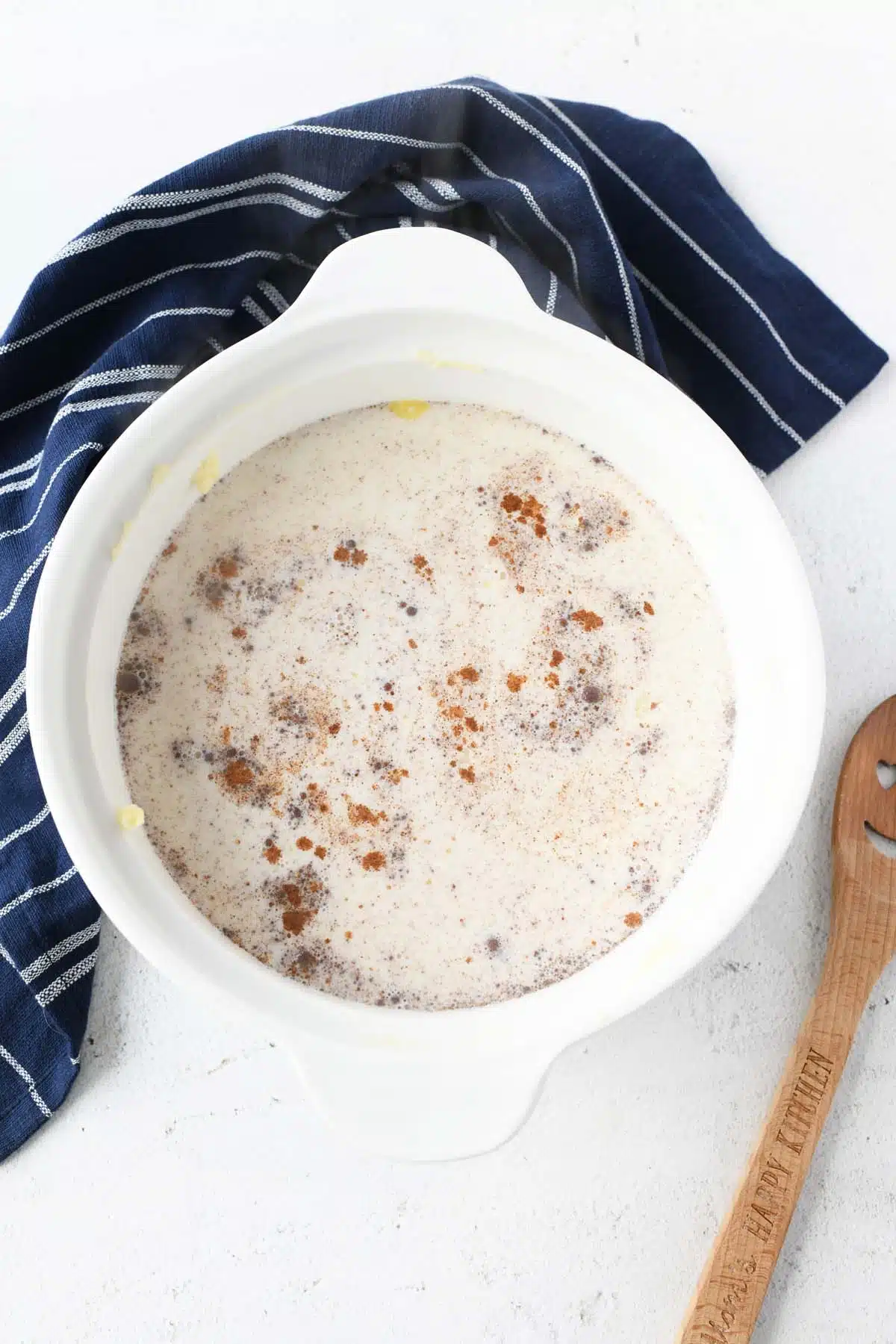 Warmed milk with rice ingredients in a white baking dish.