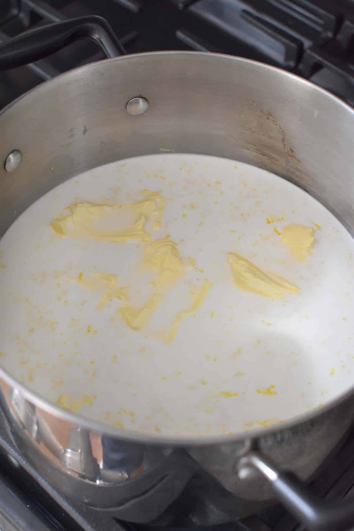 A pot of milk with milk and yellow butter inside.