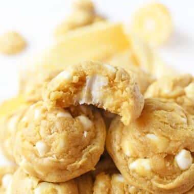 A lemon cookie on top of a tray of lemon cookies.