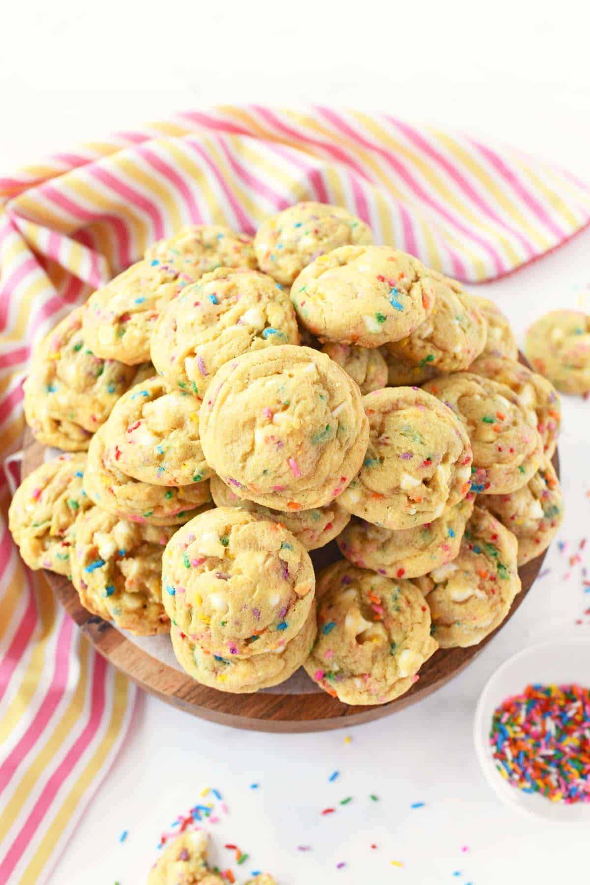 Sprinkle cookies on a tray with a pink and yellow napkins.