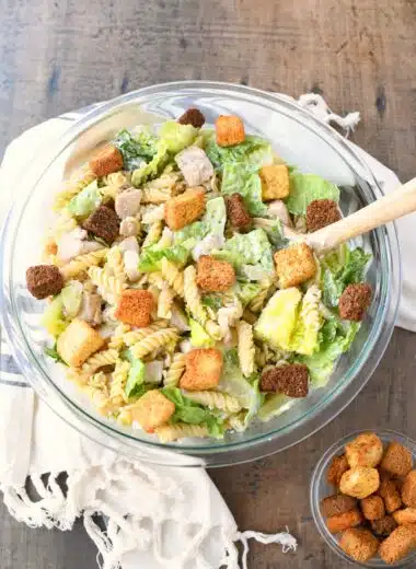 Caesar Pasta salad in a glass bowl with croutons.
