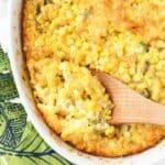 Golden-Brown Corn Pudding in a wooden spoon.