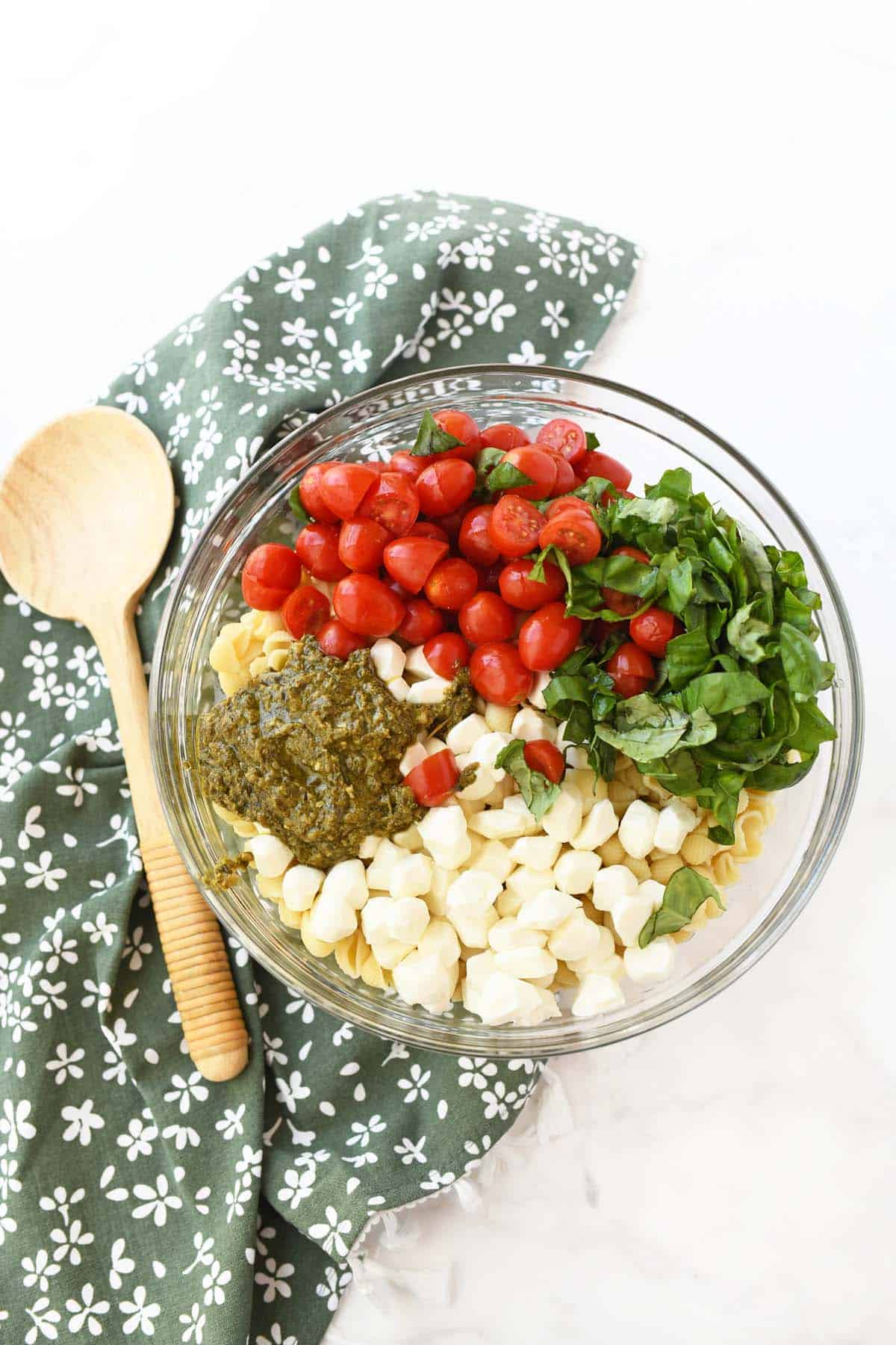 pesto salad ingredients in a glass bowl.