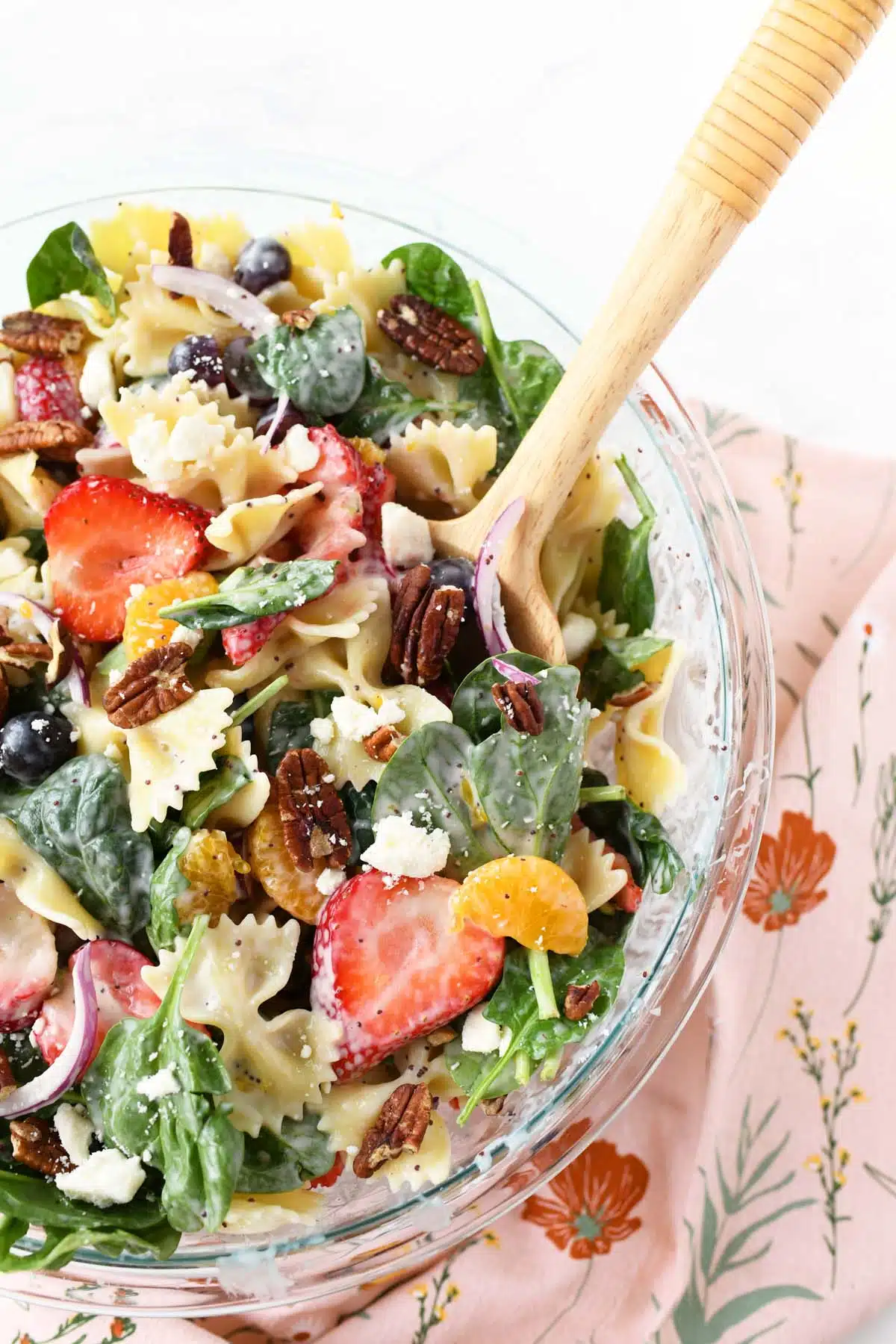 A wooden spoon in colorful Strawberry Fields Salad.