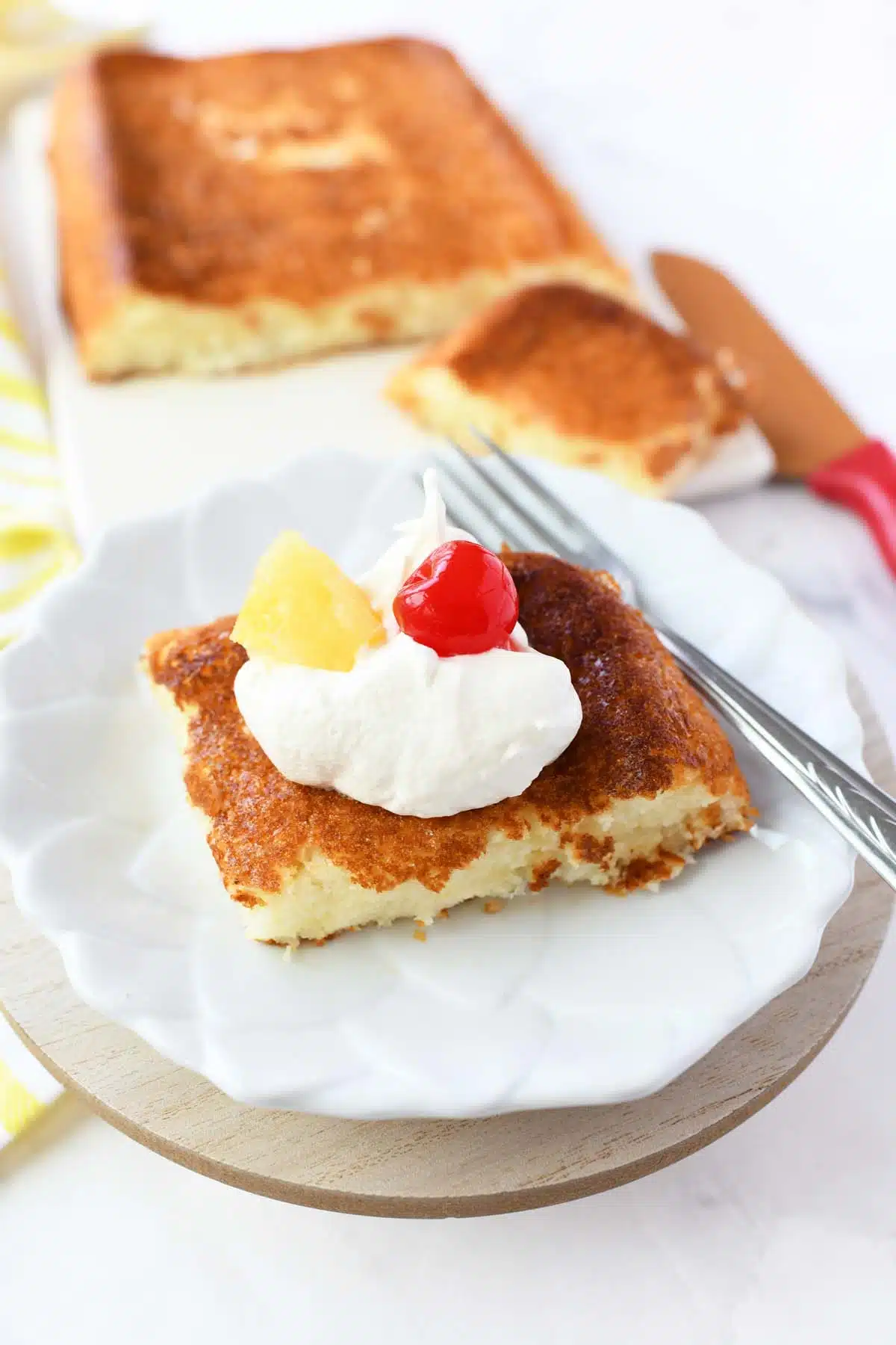 A slice of pineapple angel food cake with cherry and pineapple