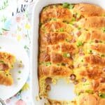 A golden brown crescent roll casserole in a white baker.