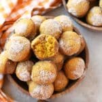 Mini pumpkin muffins with a bite taken out of one.