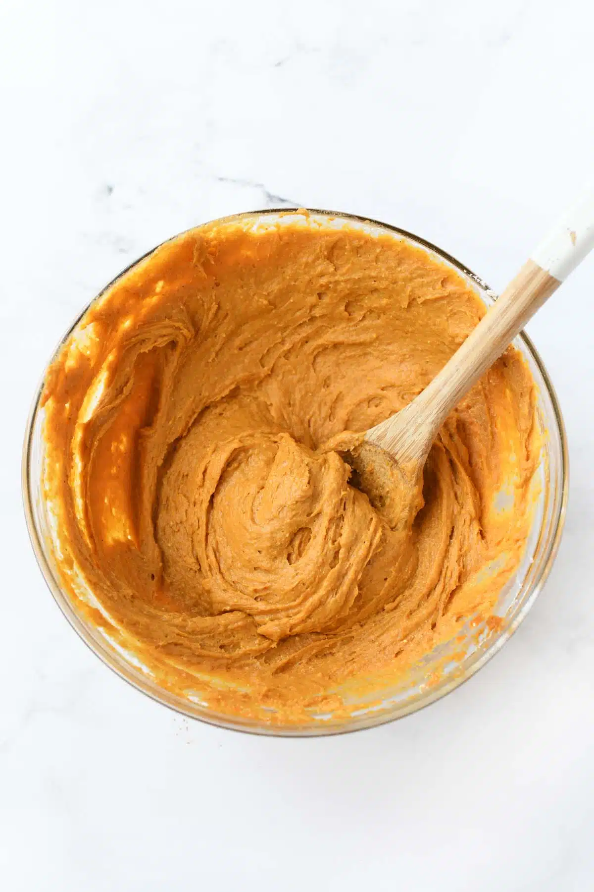 Pumpkin cookie batter in a glass bowl.