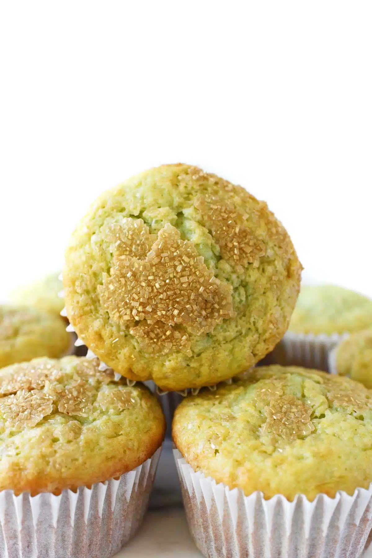 A fluffy pistachio muffin stacked.