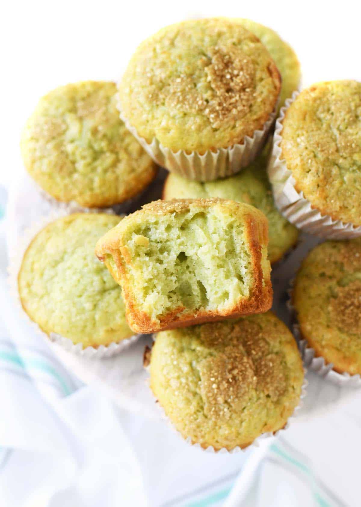 Fluffy pistachio muffins stacked on a platter.