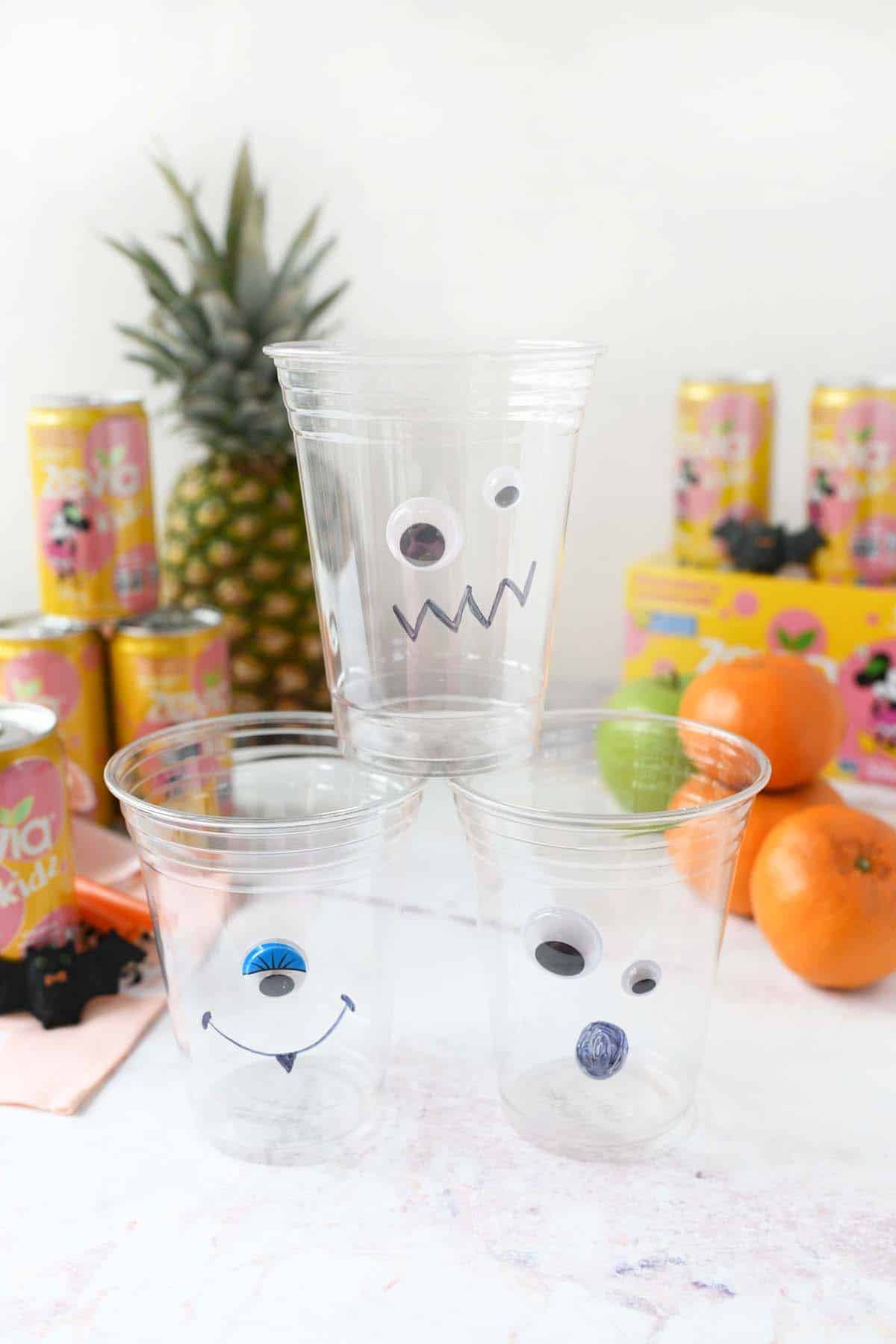 Silly monster faces with googly eyes on plastic cups.