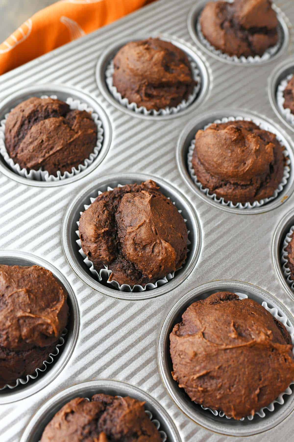 Fluffy pumpkin muffins in a cupcake pan.