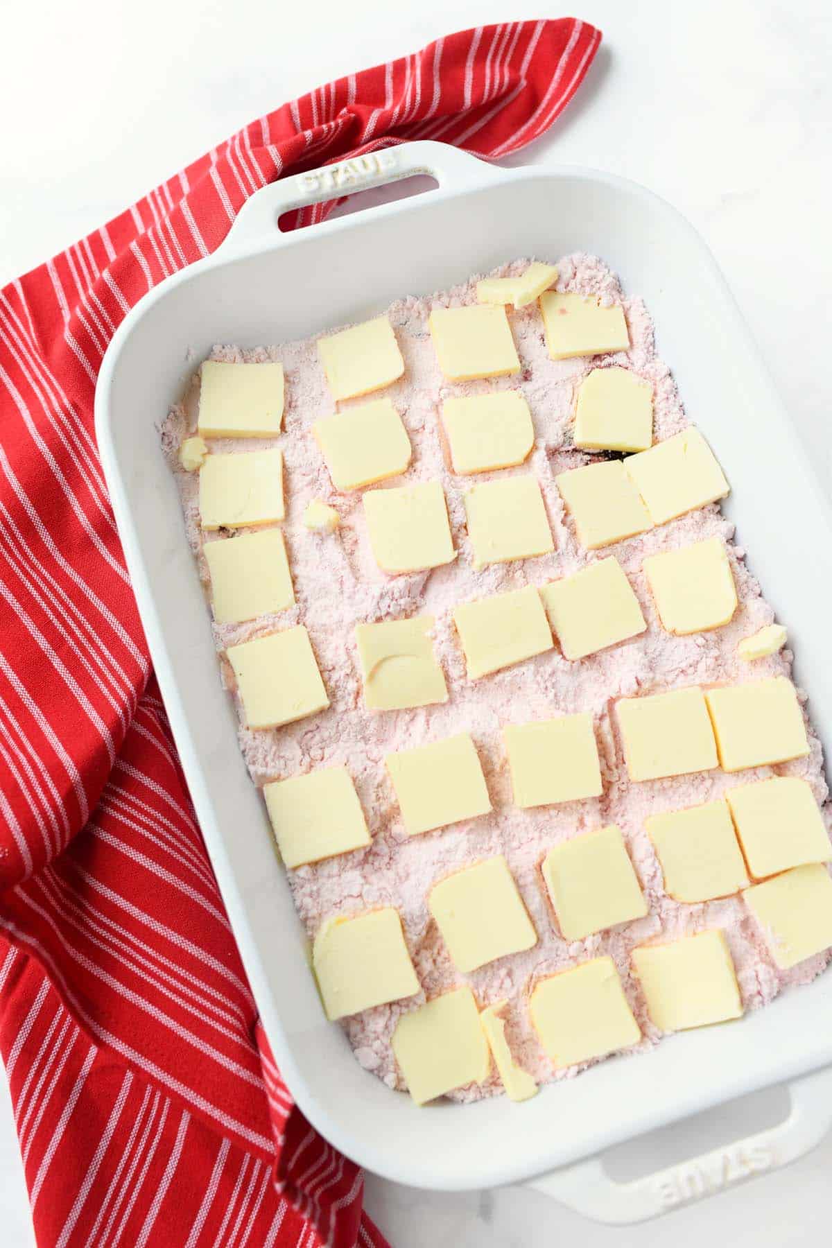Butter pats over pink cake mix.
