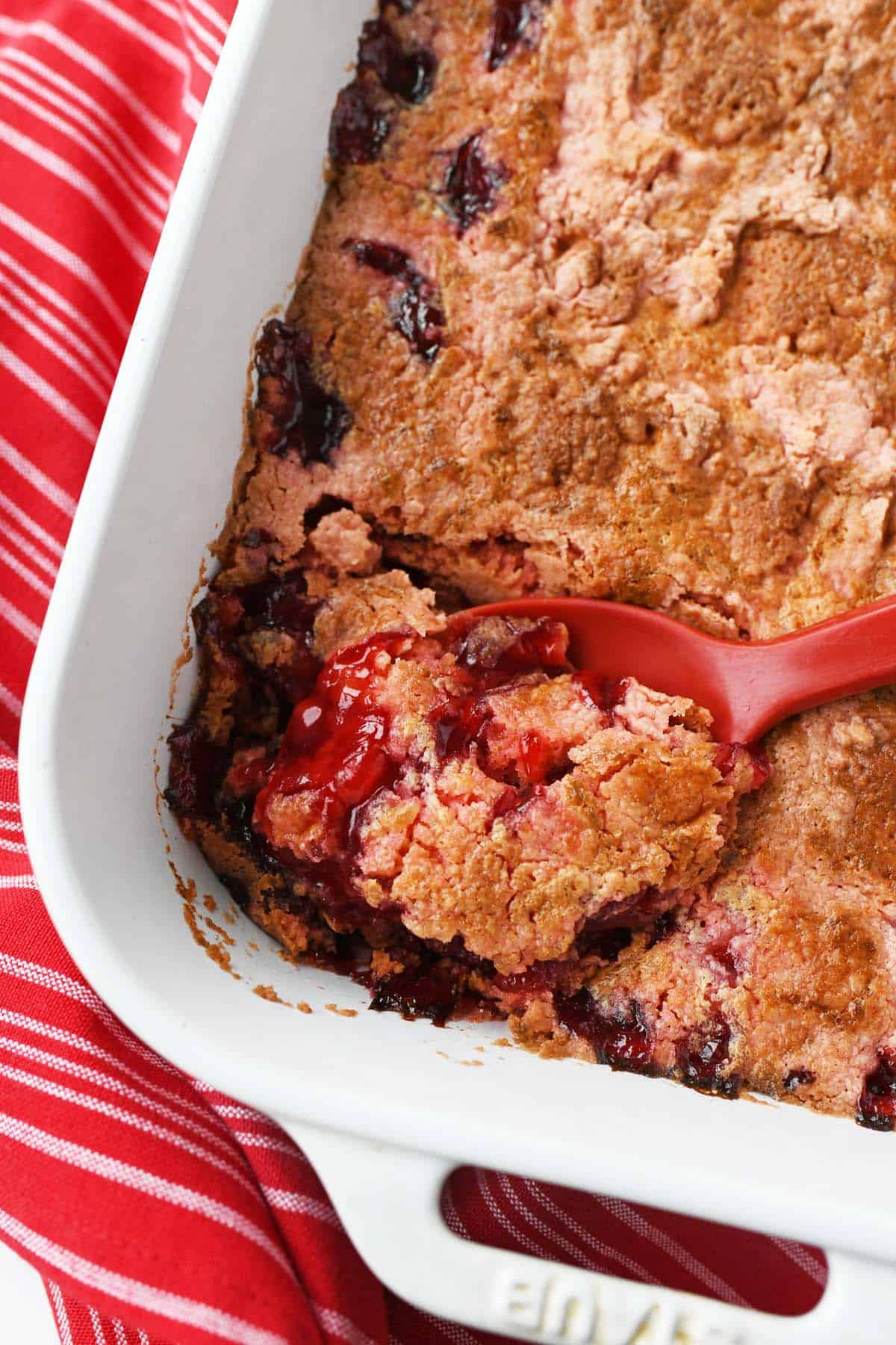 A spoon of baked cherry dump 
cake. 