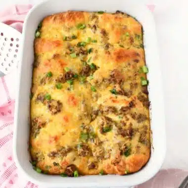 A baked sausage crescent casserole in a white baking dish.