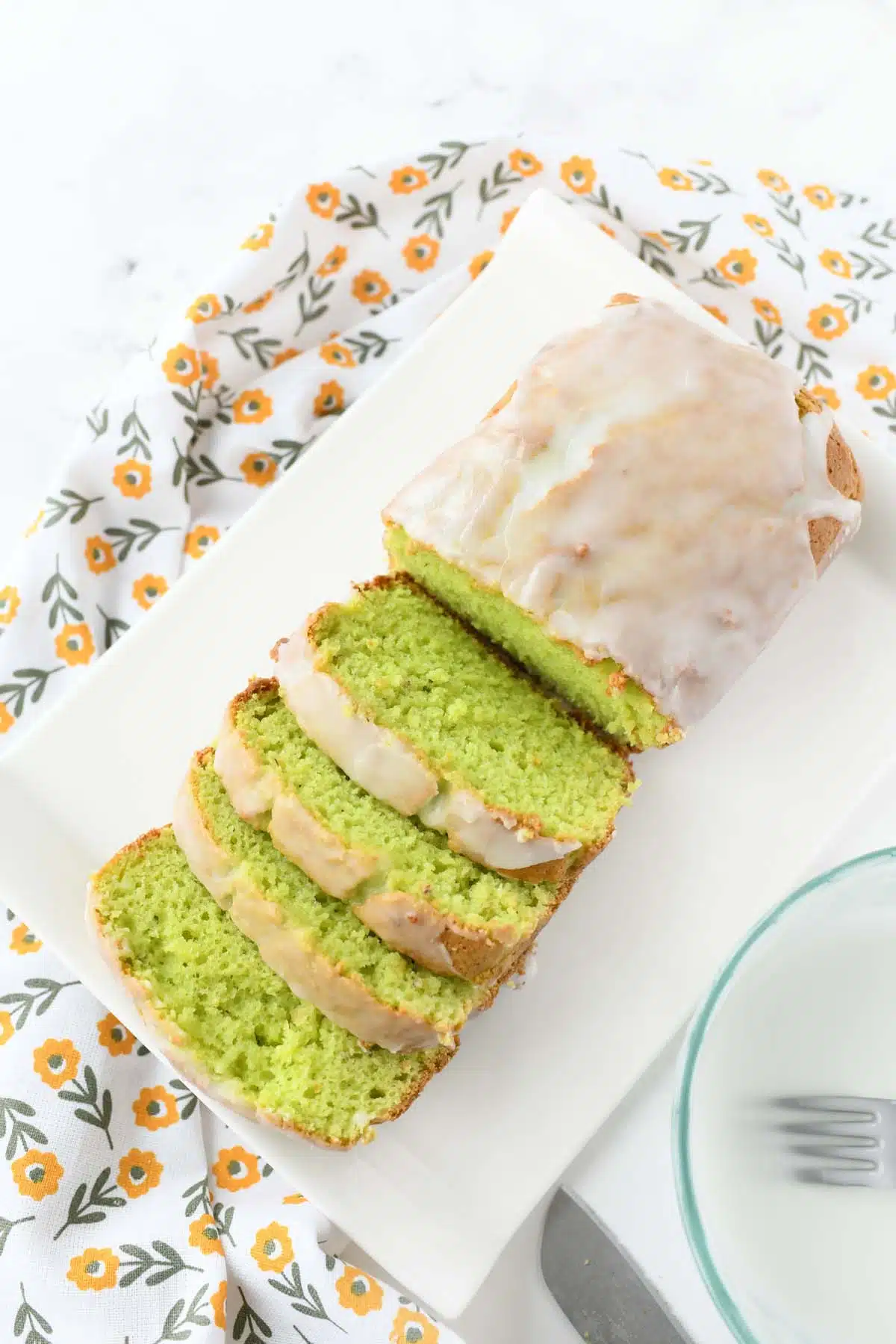 Iced pistachio quick bread on a white tray.