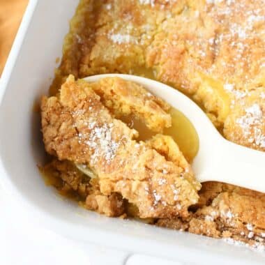 A white spoon filled with lemon dump cake.