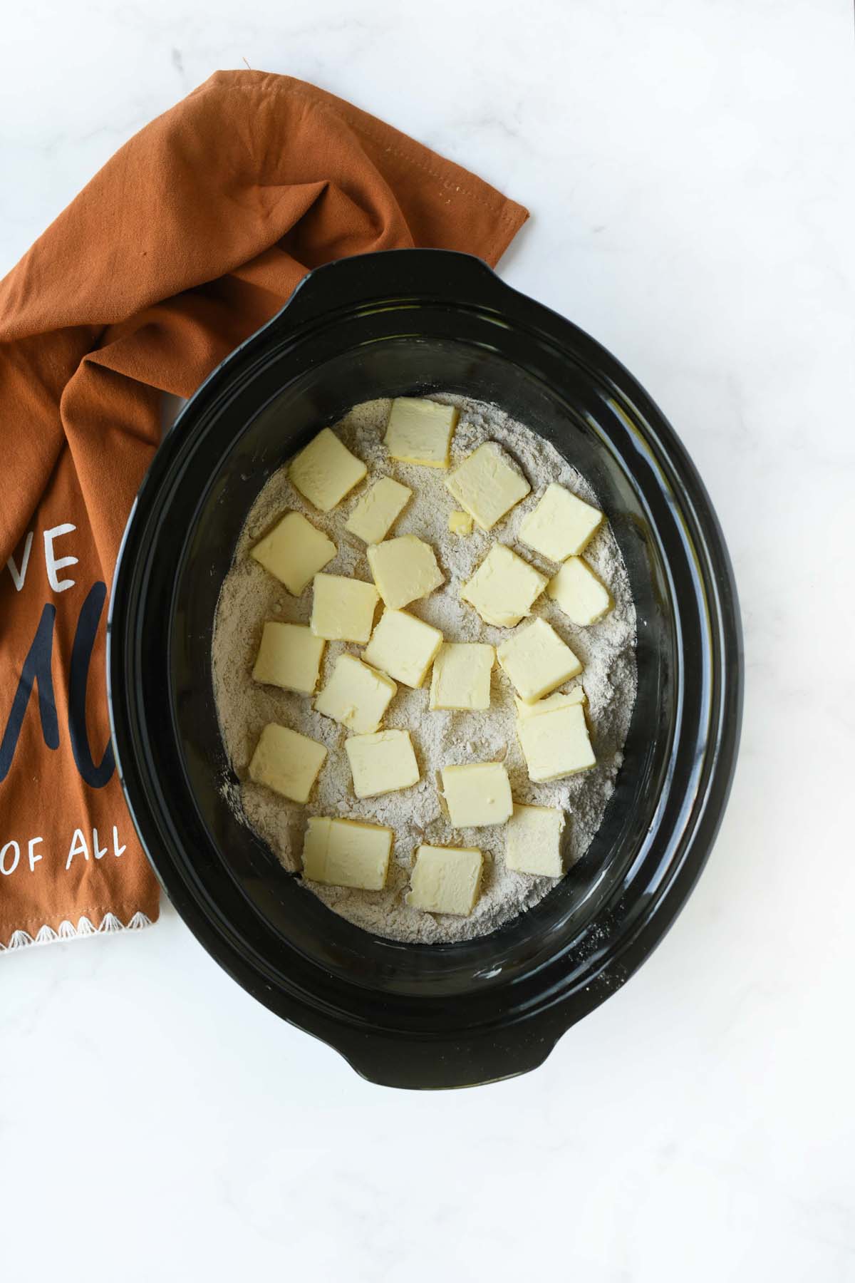 Butter pats on cake mix in a slow cooker.