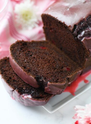 Pink iced, sliced chocolate cherry maraschino cake.