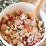 A white bowl with BLT chicken salad inside and a wooden spoon.