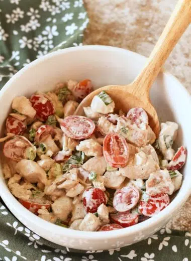 A white bowl with BLT chicken salad inside and a wooden spoon.