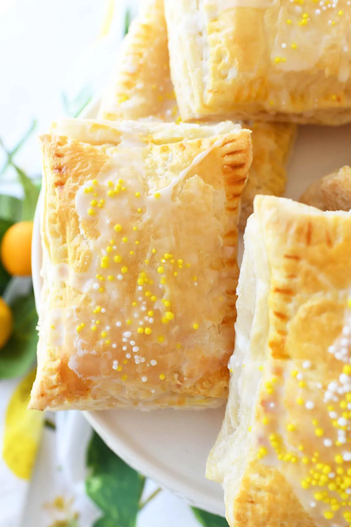 Flaky lemon puff pastry on a white tray with a lemon napkin.