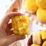 A hand holding a split in half peach pie cupcake.