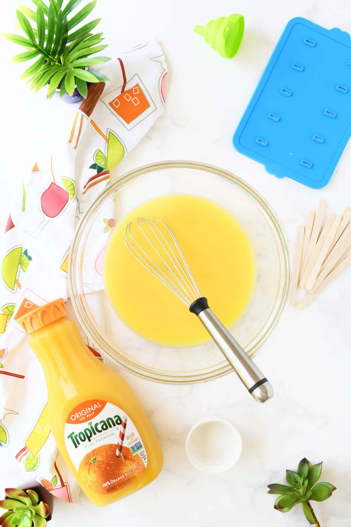 A large glass bowl with orange cream pops mixture inside.