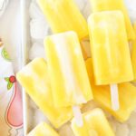Frozen orange cream pops over ice cubes.