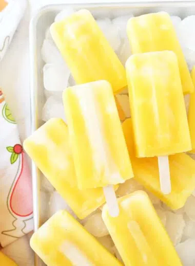 Frozen orange cream pops over ice cubes.