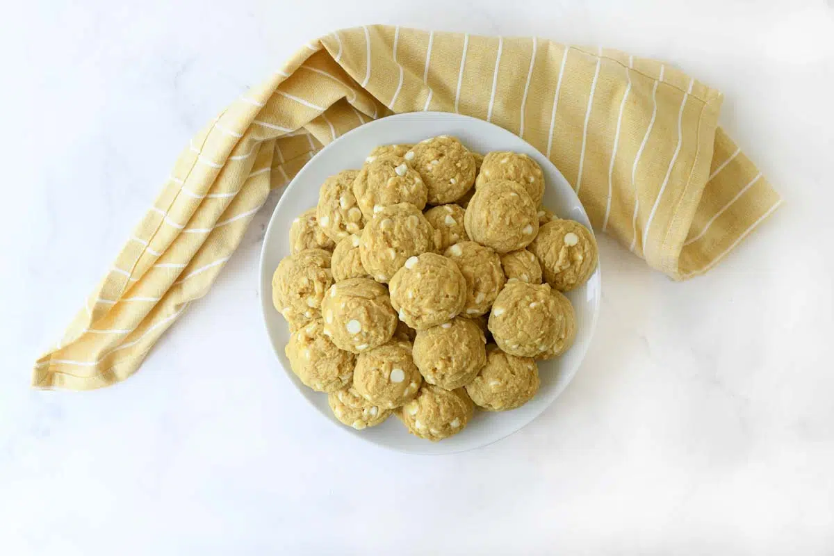 A whtie plate of banana pudding cookies with a yellow napkin.
