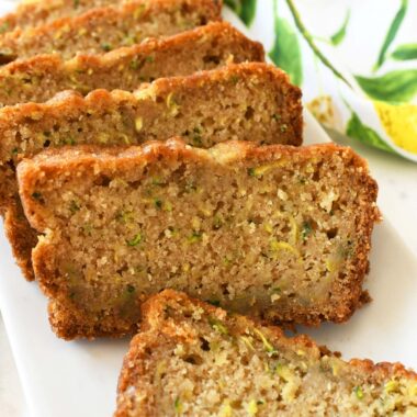 Slices of lemon zucchini bread sliced on a white plate.