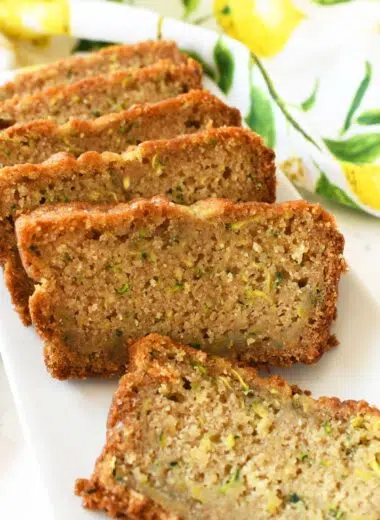 Slices of lemon zucchini bread sliced on a white plate.